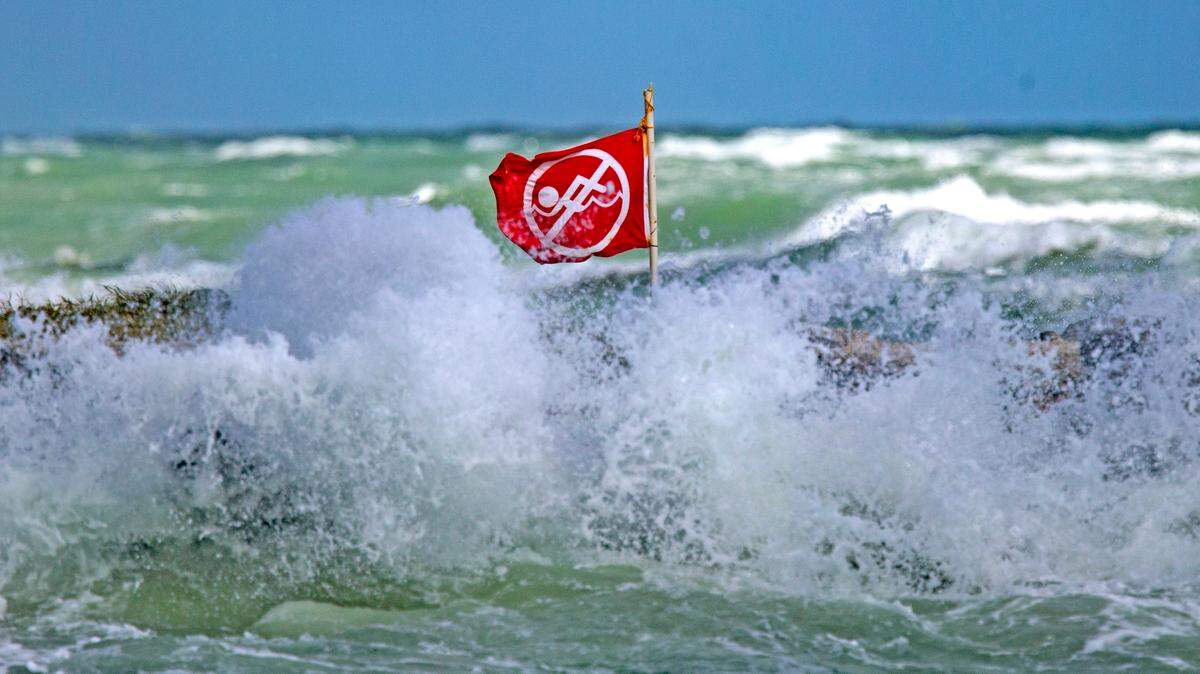 A no swimming flag as the waves crash against rocks at the Haulover Beach Park during a November 2021 rip current alert from the National Weather Service.