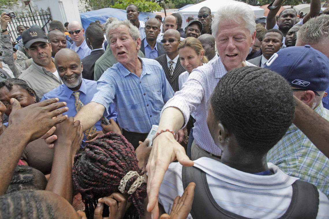 Haiti President René Préval walks with former U.S. Presidents George W. Bush and Bill Clinton in March 2010 as they shake hands with Haitians in an earthquake survivors’ camp near the destroyed presidential palace in Port-au-Prince. Bush and Clinton co-chaired the Clinton Bush Haiti Fund to raise money after the Jan. 12, 2010, quake.