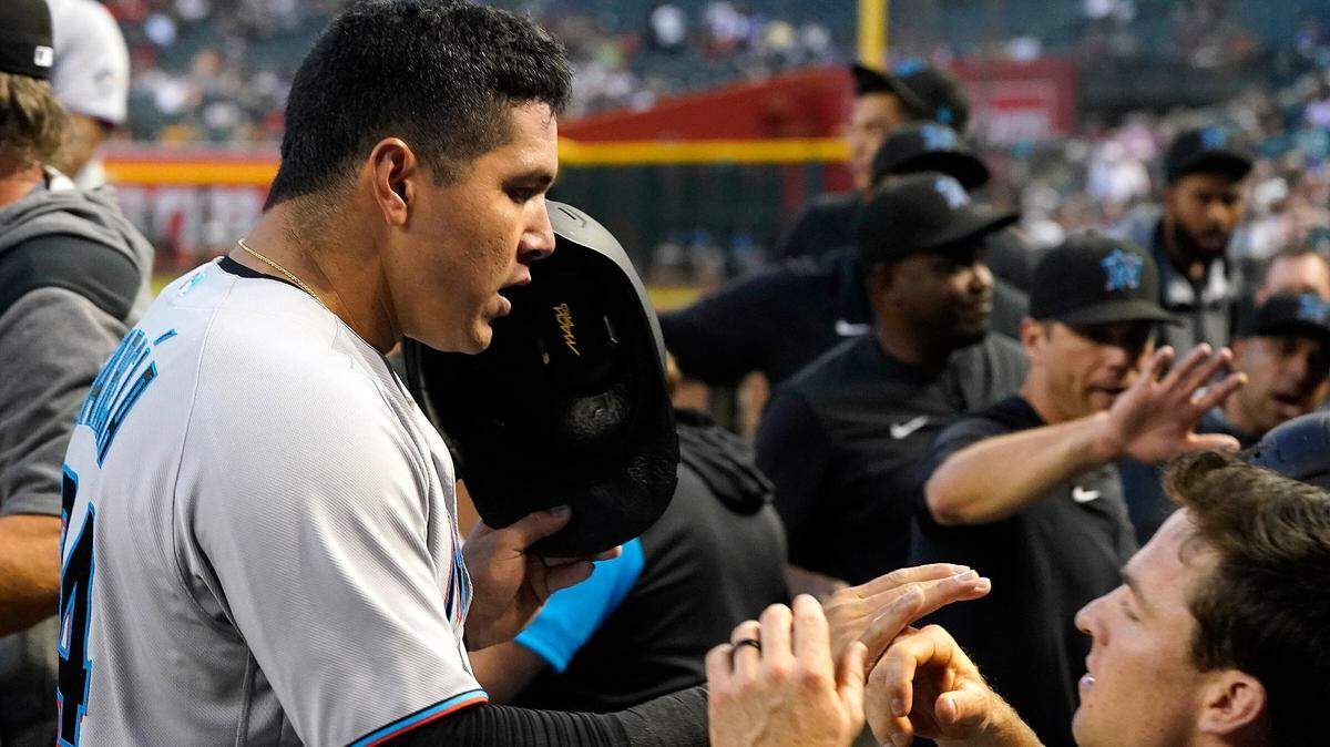 Miami Marlins’ Avisail Garcia, left, gets greeted with a high-five from Joey Wendle, right, after scoring a run against the Arizona Diamondbacks during the second inning of a baseball game Monday, May 9, 2022, in Phoenix.