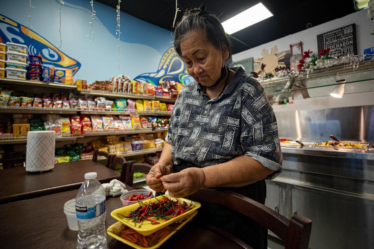 “Nanay” Linda Blanco prepares peppers at Manila Kantina in Miami, on Monday, Oct. 10, 2022.