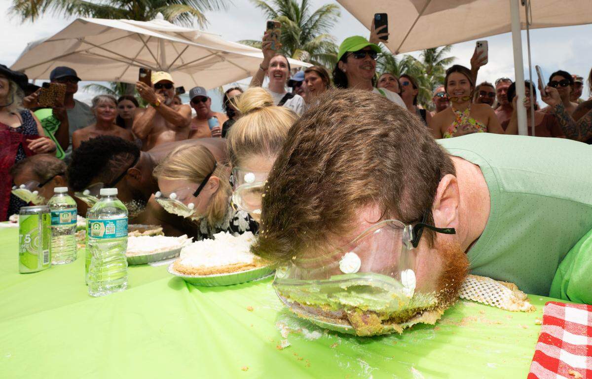 Joshua Mogle, right, of Altoona, Iowa, buries his face in a Key lime pie as he eats his way to victory at the World Famous Key Lime Pie Eating Championship Tuesday, July 4, 2023, in Key West.
