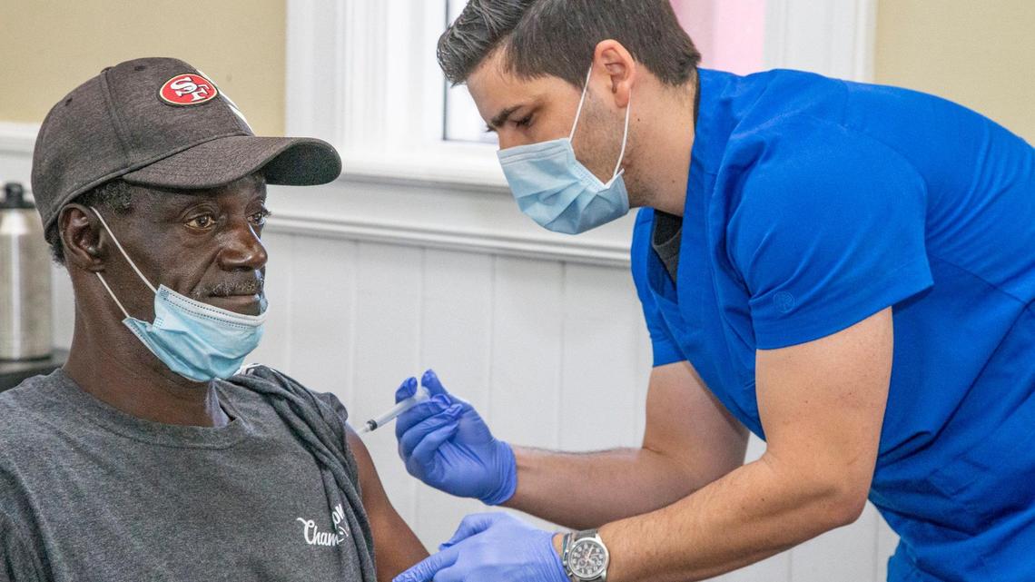 El asistente médico Mauricio García inyecta a Richard Anthony Sanders, residente de Chapman Partnership, la vacuna Moderna COVID-19. Las vacunas se administraron a los residentes, el personal y las familias en el refugio para personas sin hogar el jueves 22 de abril de 2021.