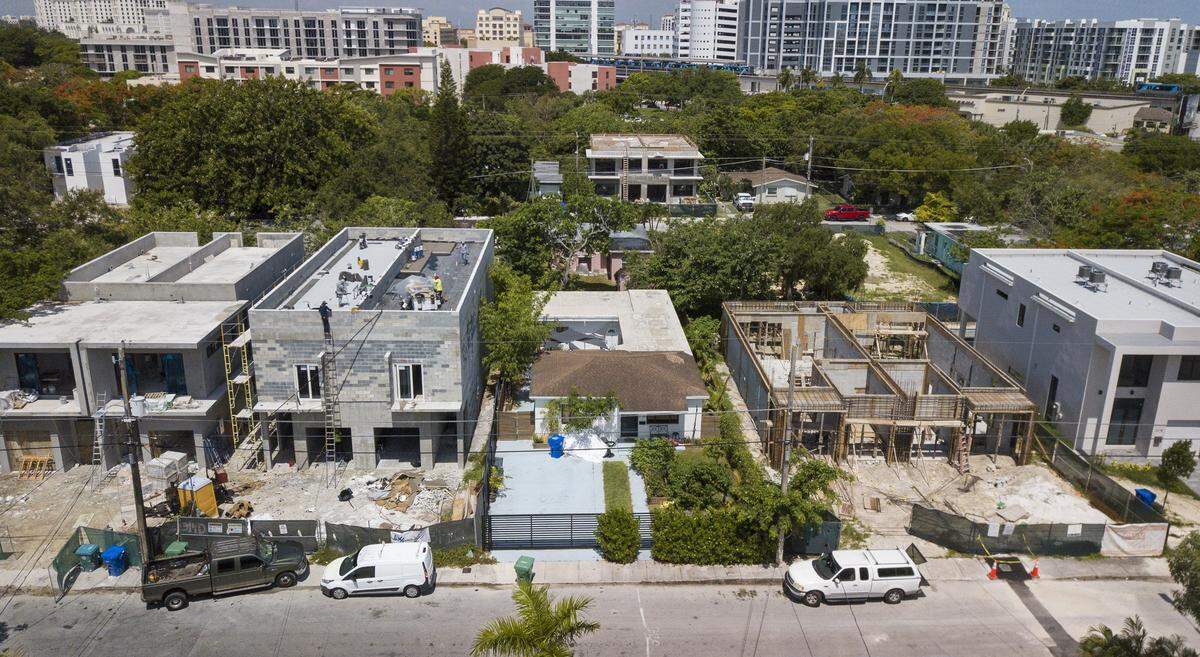 Luxury homes and duplexes rise along what was once a street of modest houses in Miami’s historically Black West Coconut Grove on Friday, June 17, 2022. The Black community is disappearing amid rapid gentrification.