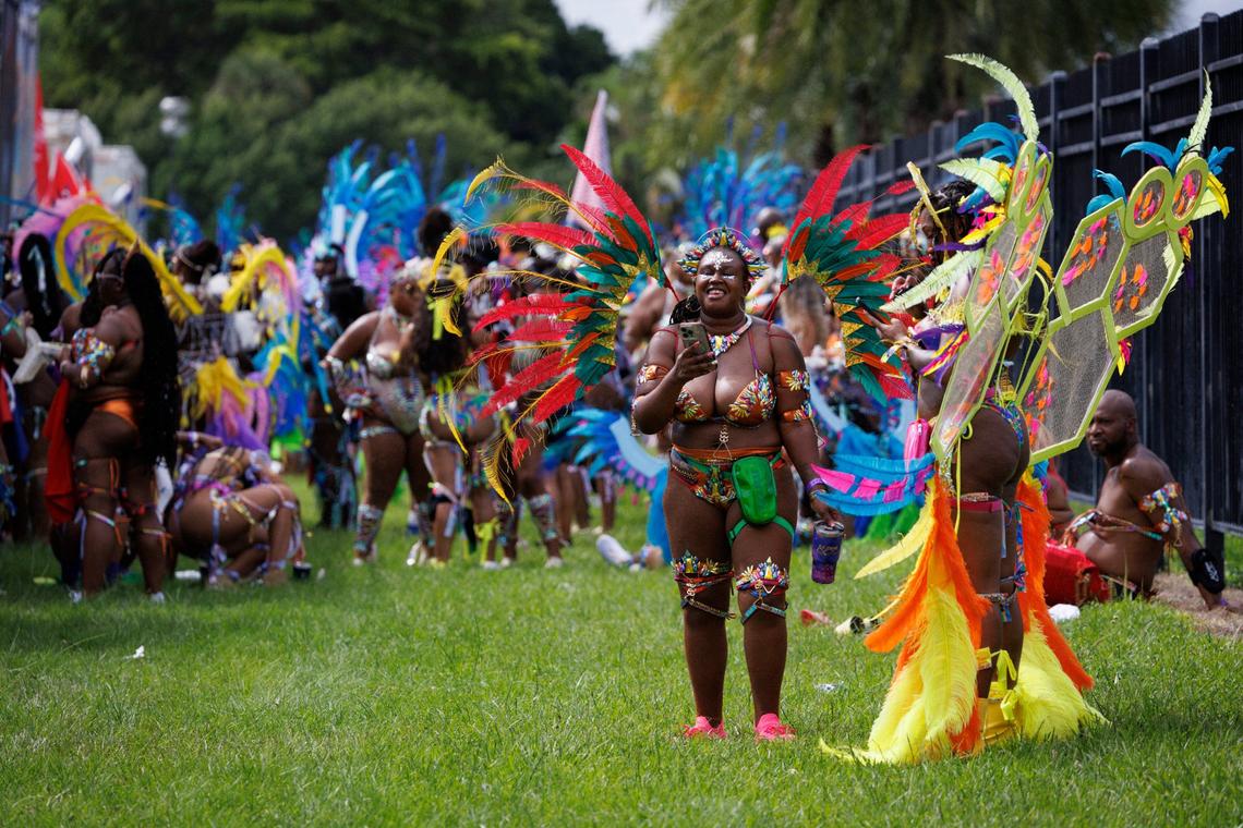 Lynette Davis, center, a first-time Carnival-goer, smiles with her friend before the masqueraders line up for the Parade of Bands at Miami Carnival on Sunday, Oct. 13, 2024, at Miami-Dade County Fair Expo.