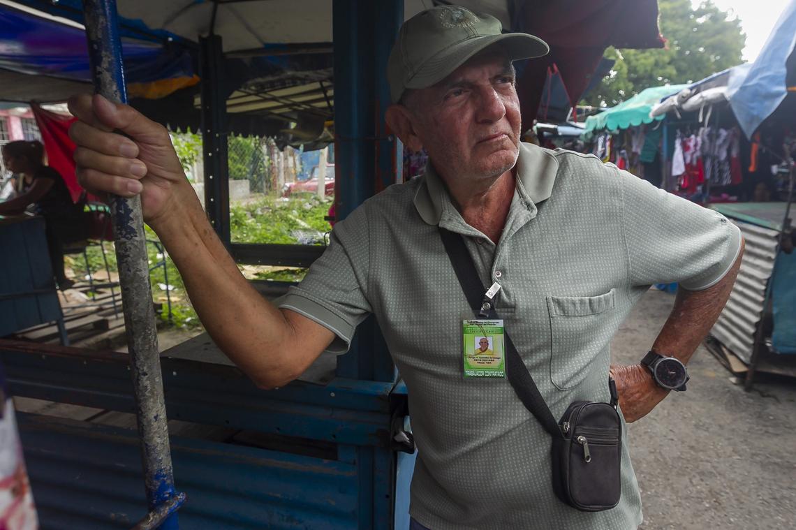Jorge V. Castillo, 72, sells dresses sewn by his wife at the Virgen del Camino market.