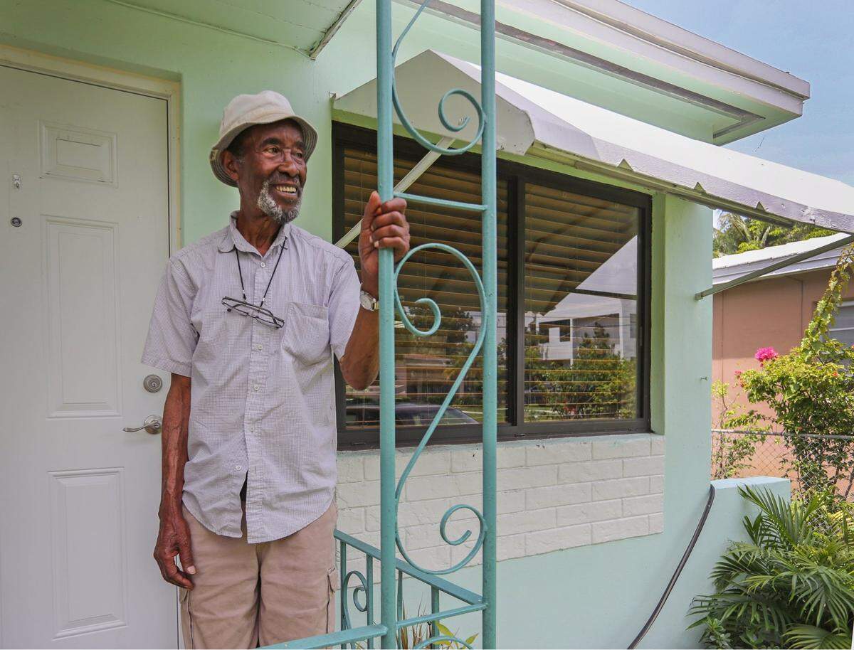 Wilson Williams, 90, a retired Sears maintenance worker, poses on the porch of his longtime home in Miamis historically Black West Coconut Grove on Wednesday, June 15, 2022. The nonprofit group Rebuilding Together is installing new impact windows at Williams’ house.
