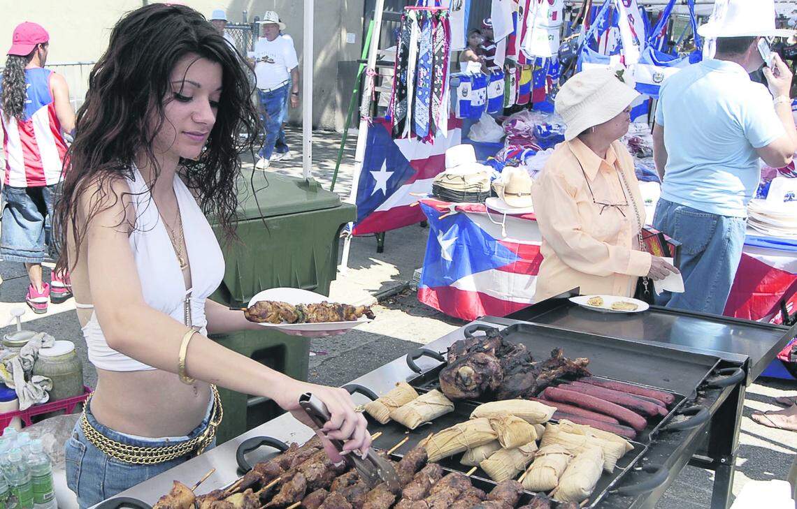 Vendor Cosette Constantine prepares some shish kabob at one of the food booths at a previous Calle Ocho celebration. The event’s return is a boon for mom-and-pop vendors.