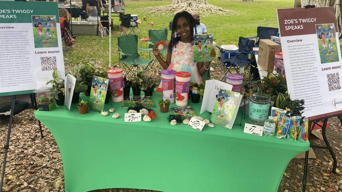 Zoë Madison Orndorff is one of three Miami-area winners of the OneUnited Bank’s Financial Literacy Essay and Art Contest. She is pictured here selling her books, pet rocks and snacks.