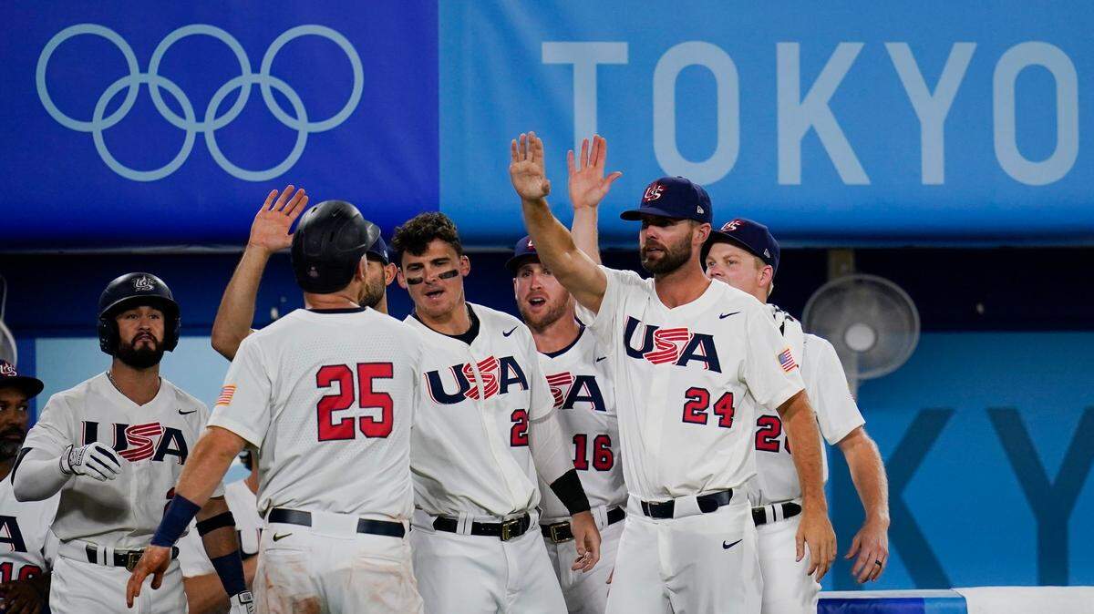 United States’ Todd Frazier (25) celebrate with teammates after scoring on a hit by Mark Kolozsvary during a semi-final baseball game at the 2020 Summer Olympics, Thursday, Aug. 5, 2021, in Yokohama, Japan. (AP Photo/Sue Ogrocki)