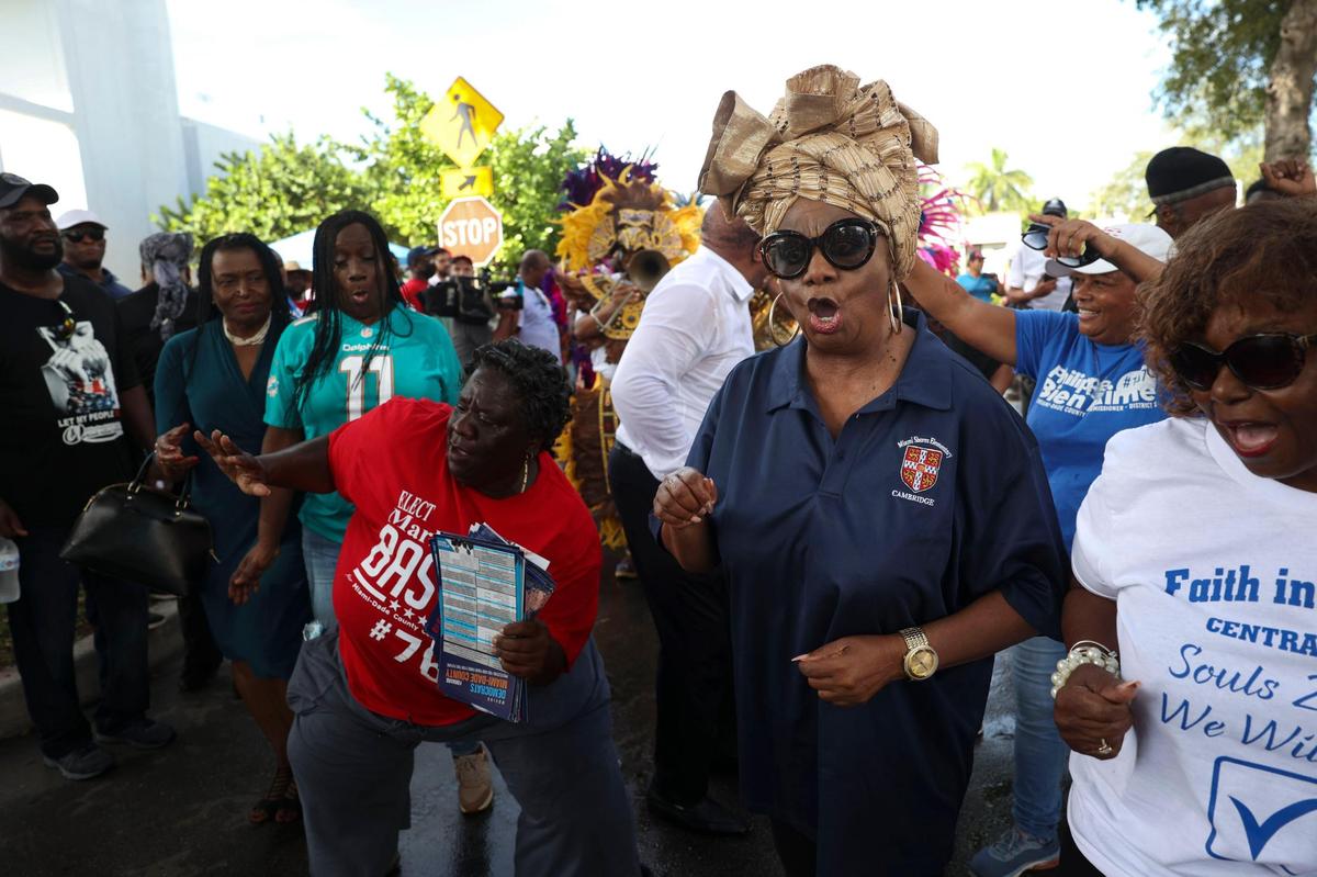Miami-Dade School Board member Dorothy Bendross-Mindingall dances with the Junkanoo band during a Souls to the Polls event outside of the Joseph Caleb Center on Sunday, Nov. 6, 2022, in Liberty City, Miami.