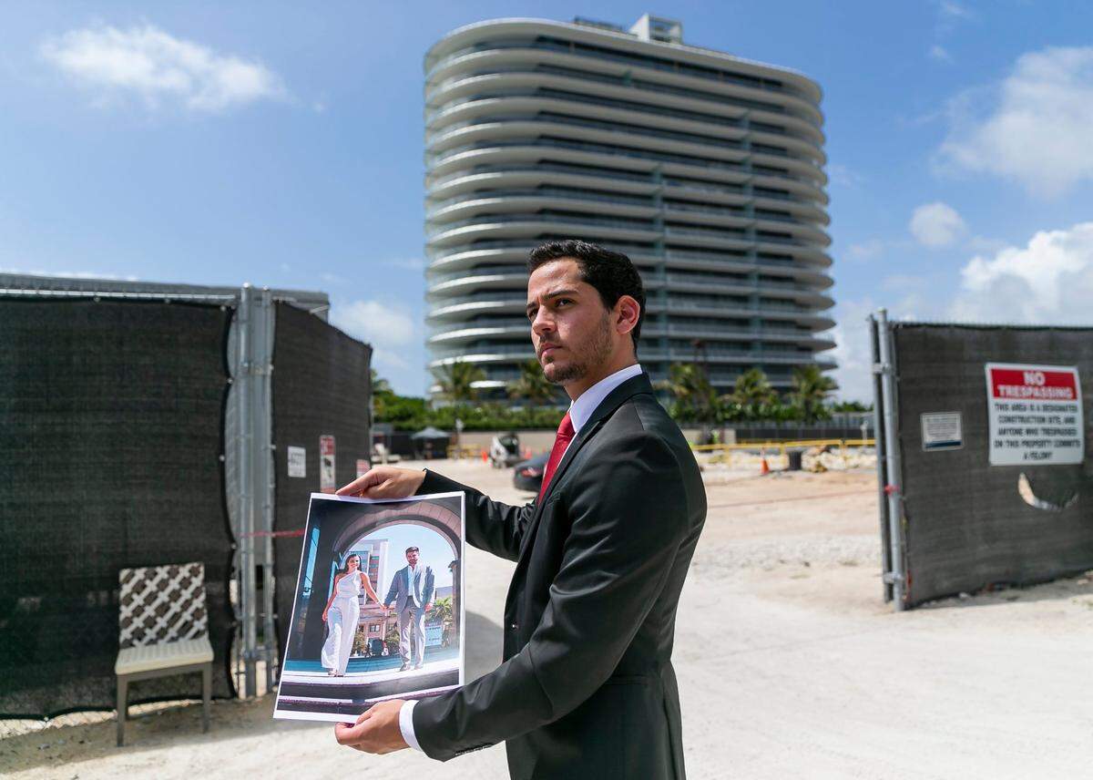 Tras una rueda de prensa en Surfside, Florida, el jueves 14 de abril de 2022, Martin Langesfeld sostiene una foto de su hermana, Nicole Langesfeld, y su cuñado, Luis Sadovnic, que murieron en el colapso de las Champlain Towers South.