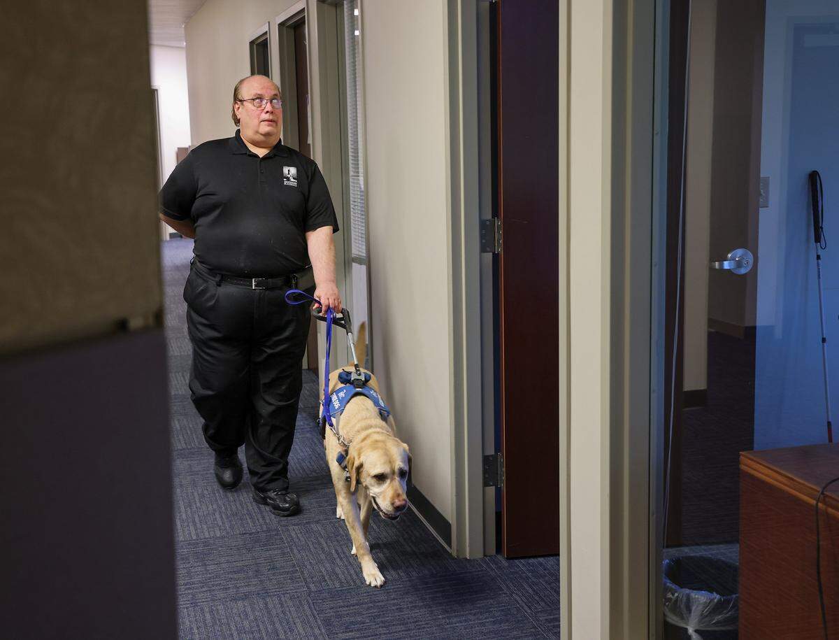 Jose Lopez Masso, Vice President of Public Affairs and Government Relations at Lighthouse of Broward, is guided back his at his office by Louis on Wednesday, July 9, 2025, in Sunrise, Florida.