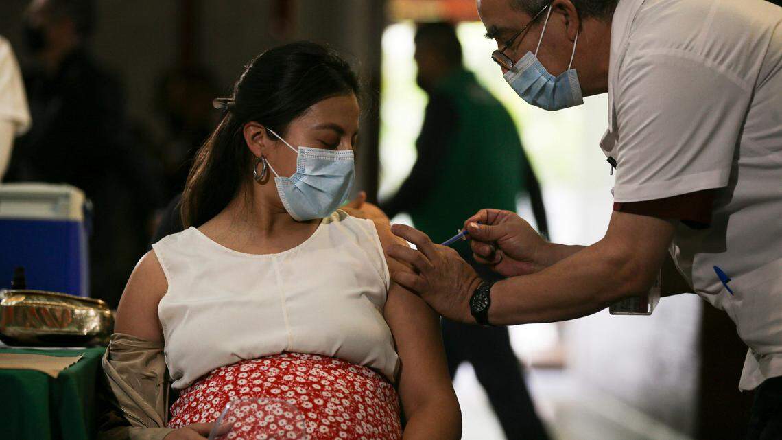 A pregnant woman gets a Pfizer vaccine shot for COVID-19 at a library converted into a vaccination center in Mexico City, Thursday, May 13, 2021. A new study reveals how the timing of vaccination affects antibody levels at the time of delivery.