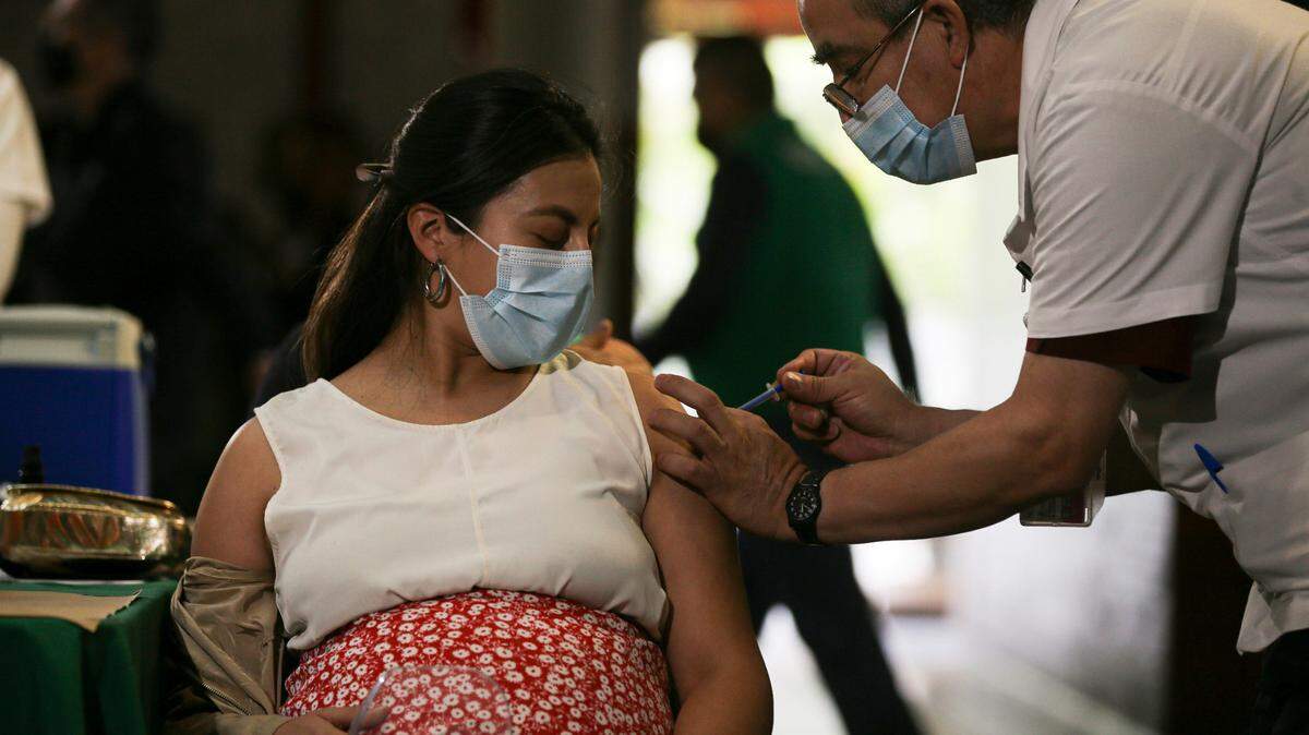A pregnant woman gets a Pfizer vaccine shot for COVID-19 at a library converted into a vaccination center in Mexico City, Thursday, May 13, 2021. A new study reveals how the timing of vaccination affects antibody levels at the time of delivery.