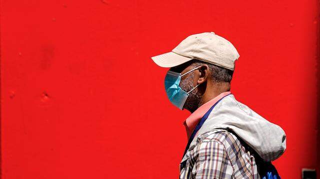 In this stock photo, a pedestrian is seen wearing a protective mask as a precaution against the spread of the coronavirus in Philadelphia on Friday, April 22, 2022.