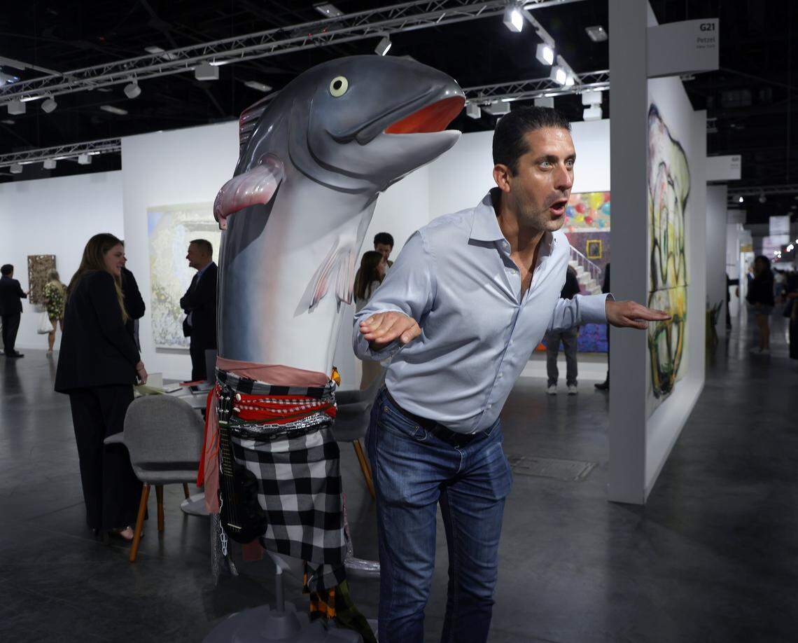 Cosima Von Bonin's “What If It Barks 4” (Black Ukulele version) 2018 is an eye catcher as a fair-goer tries to mimic the art piece at Wednesday's VIP opening at Art Basel Miami Beach on its opening day of the 23rd annual Art Basel in Miami Beach, Florida on Wednesday, December 3, 2025. The 23rd edition of Art Basel Miami Beach kicked off Wednesday as VIPs surveyed the collection of international and local galleries.