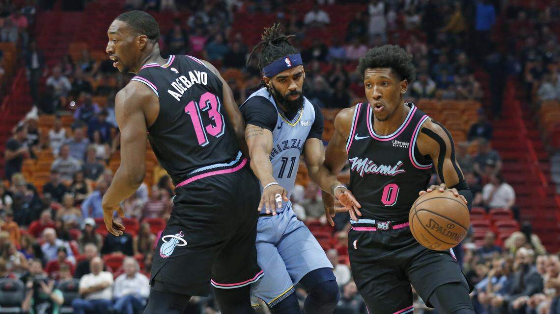 Miami Heat forward Bam Adebayo (13) clear’s the way for guard Josh Richardson (0) as Memphis Grizzlies guard Mike Conley (11) defends in the first quarter as the Miami Heat host the Memphis Grizzlies at AmericanAirlines Arena in Miami on Saturday, January 12, 2019.