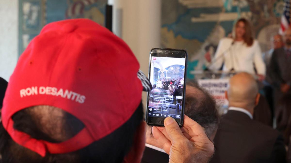 Un hombre graba a la presidenta del Miami-Dade College, Madeline Pumariega, hablando durante la conferencia de prensa en Honor a las Víctimas del Comunismo en la Freedom Tower de Miami el lunes 9 de mayo de 2022. Posteriormente, el Gov. Ron DeSantis firmó un proyecto de ley que declaraba el 7 de noviembre el “Día de las Víctimas del Comunismo”.