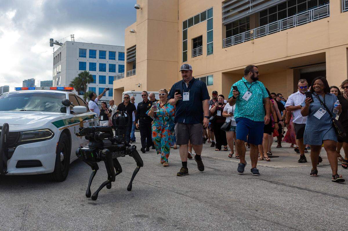 Guests followed “Spot,” a robotic dog owned by Miami-Dade Police’s Special Response Team Department to their seats during a South Florida Public Safety Regional Assets in Action Demonstration showcasing an active threat response incident in Biscayne Bay as part of the annual 2024 National Homeland Security Conference at PortMiami, Terminal J on Wednesday, July 24, 2024, in Miami, Fla.