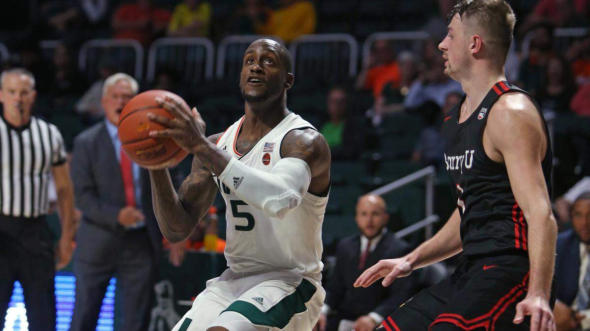 Miami Hurricanes guard Zach Johnson (5) drives against Barry University Buccaneers guard Evan Walshe (1) during the first half of an NCAA college basketball exhibition game at the Watsco Center in Coral Gables on on Tuesday, October 30, 2018.