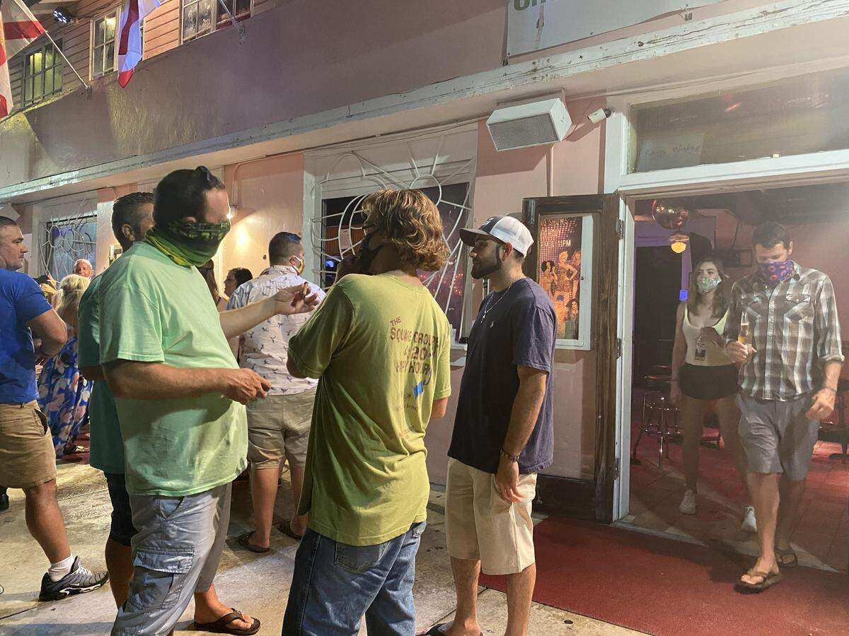 People gather outside the 801 Bourbon Bar, which reopened at 12:01 a.m. June 5, 2020.
