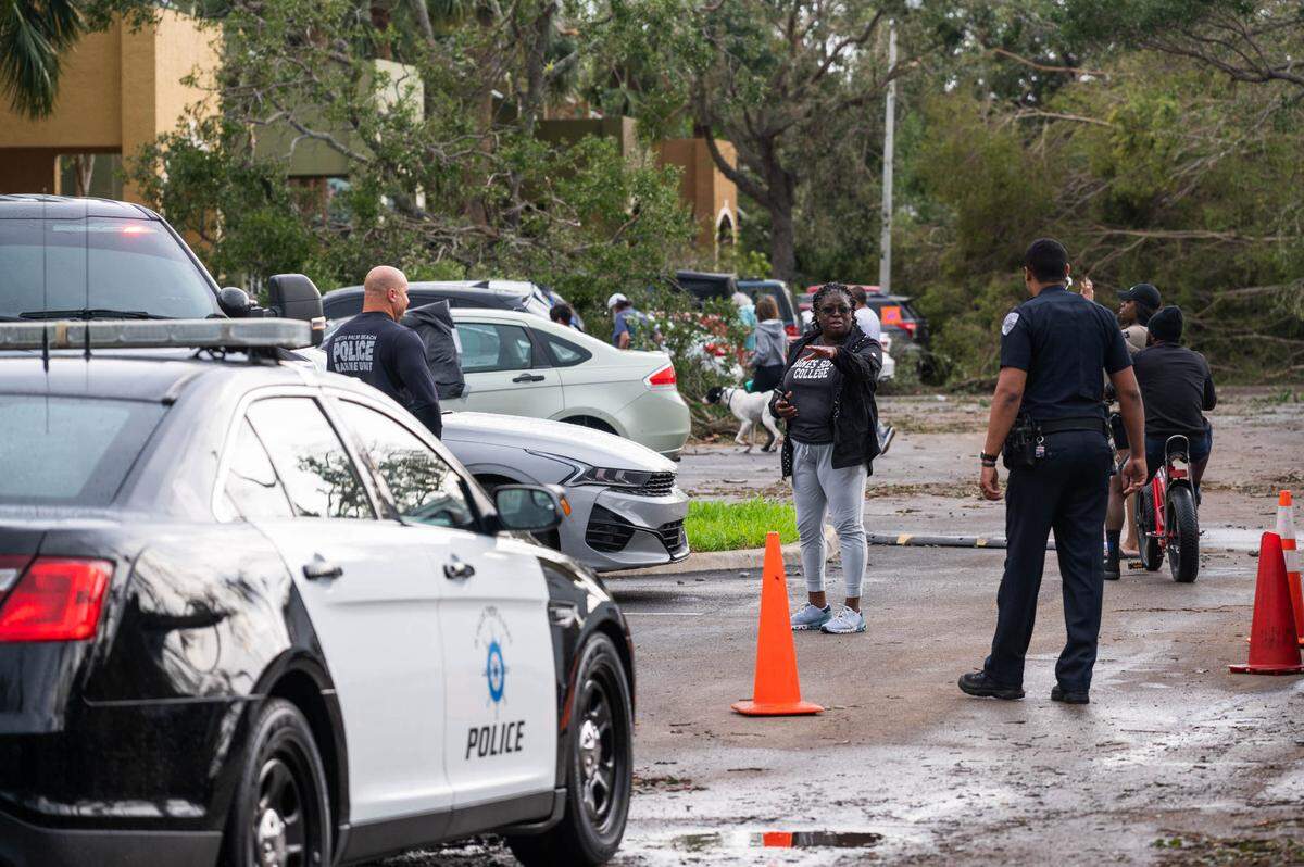 North Palm Beach Police officers speak with passers-by at the Sanctuary Cove Apartment complex while standing in front of a condemned building on Sunday, April 30, 2023, in Palm Beach Gardens, Fla. The National Weather Service confirmed an EF-1 tornado touched down in Palm Beach Gardens Saturday evening.