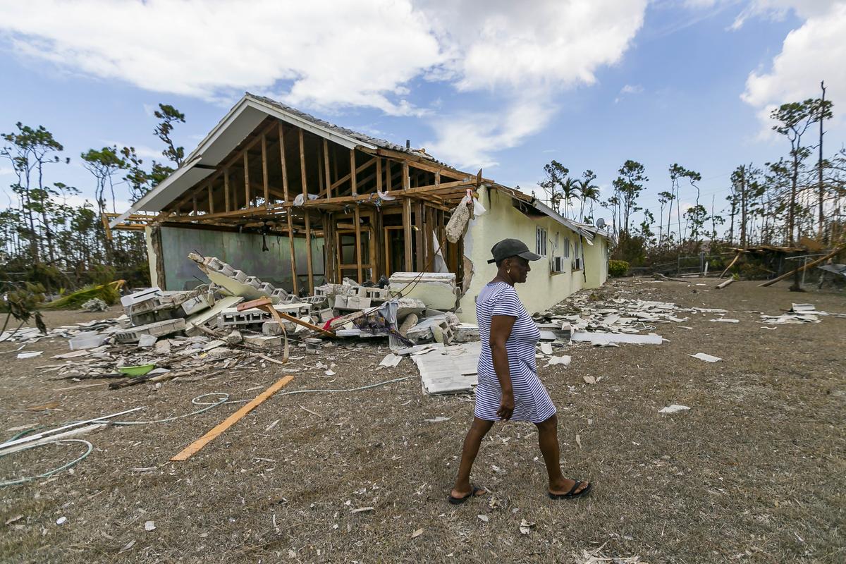 Donalee Smith, 61, a seamstress, walks through the rubble of her sister’s house in Freeport, Bahamas on Friday, September 6, 2019. Thousands of Bahamians are heading to Freeport Harbor trying to escape Hurricane Dorian’s devastation.