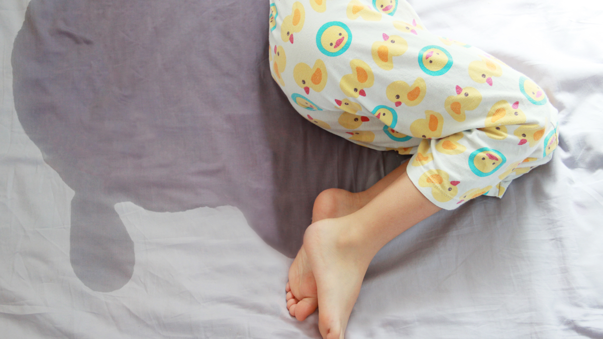 young child wets bed in pajamas