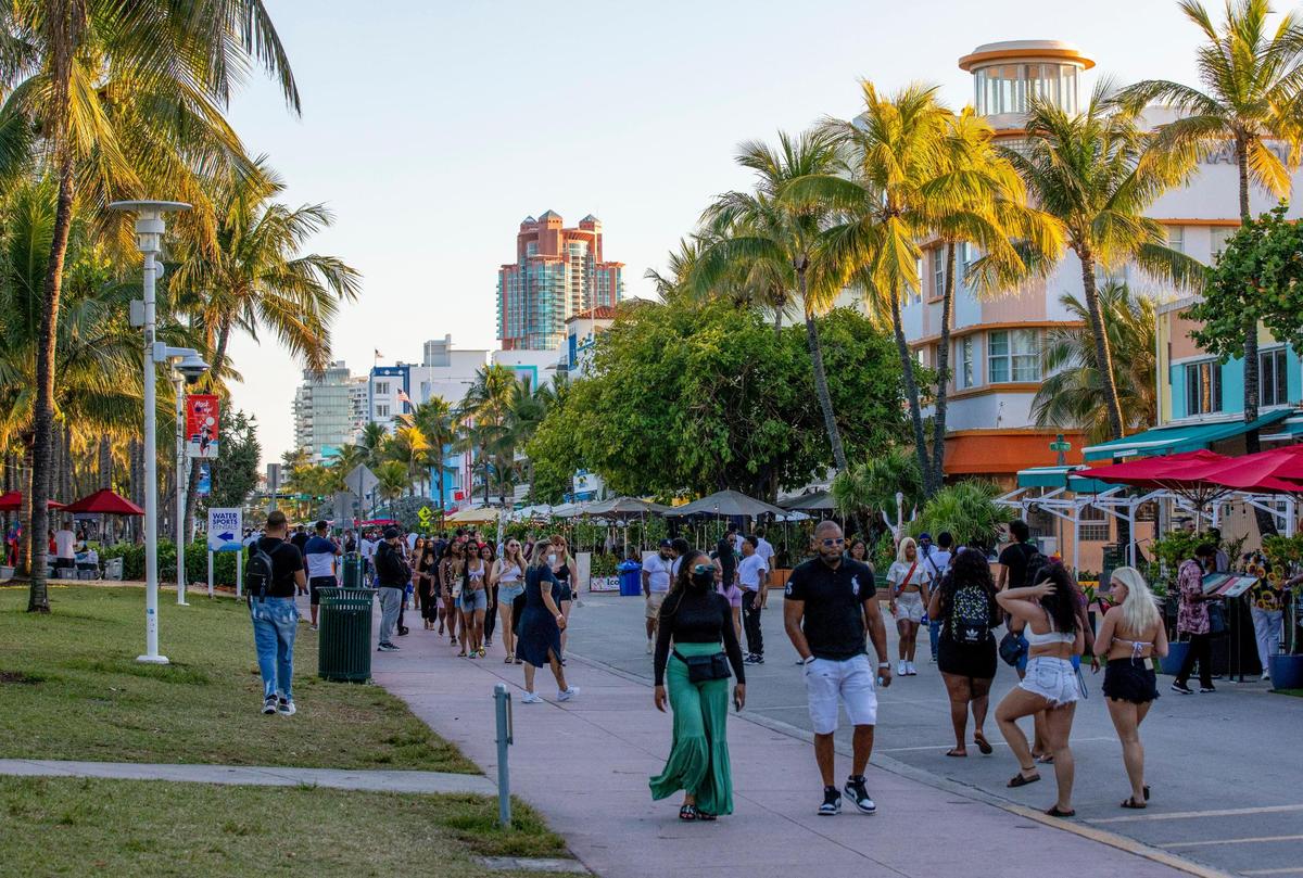 Crowds stroll through Ocean Drive before curfew in Miami Beach, Florida, on Tuesday, March 23, 2021.
