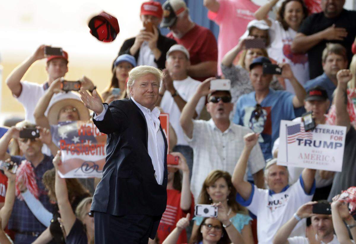 President Donald Trump throws a hat into the crowd during the “Make America Great Again Rally” at Orlando-Melbourne International Airport Feb. 18, 2017.