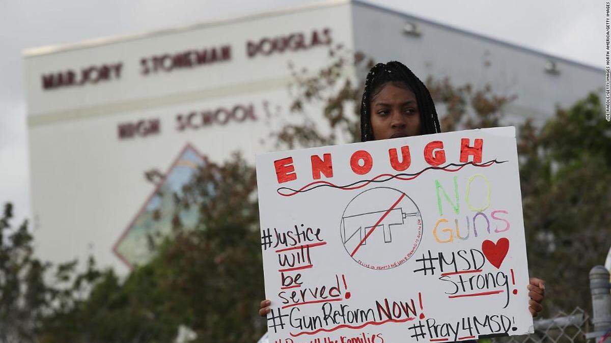 Student Tyra Heman holds a sign calling for gun reforms.