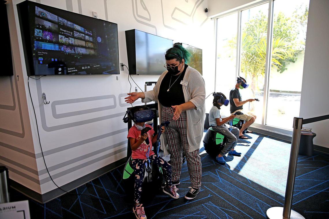 Jennifer Pinto helps Nia Patel, 5, with her headset at the new Cybrarium in Homestead. The city in South Florida just opened the world’s first cyber library — a library with advanced technological aspects — to help bridge the digital divide for its residents.