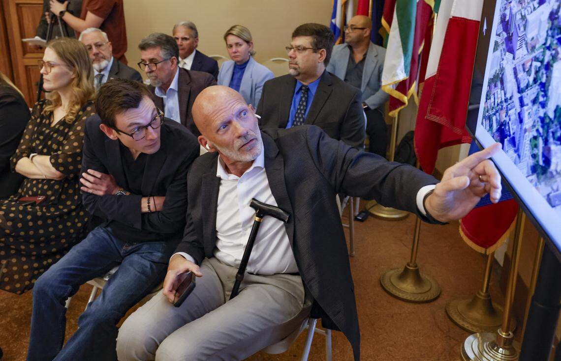 Coral Gables resident Nicolas Cabrera and community outreach consulant for Fifield, Tim Hyman, view an aerial image before the commission votes on development plans at 110 Phoenetia Ave at the site of the "Garden of Our Lord" and an ancient tree that is believed to be at least as the century old City of Coral Gables, Florida on Tuesday, February 10, 2026.