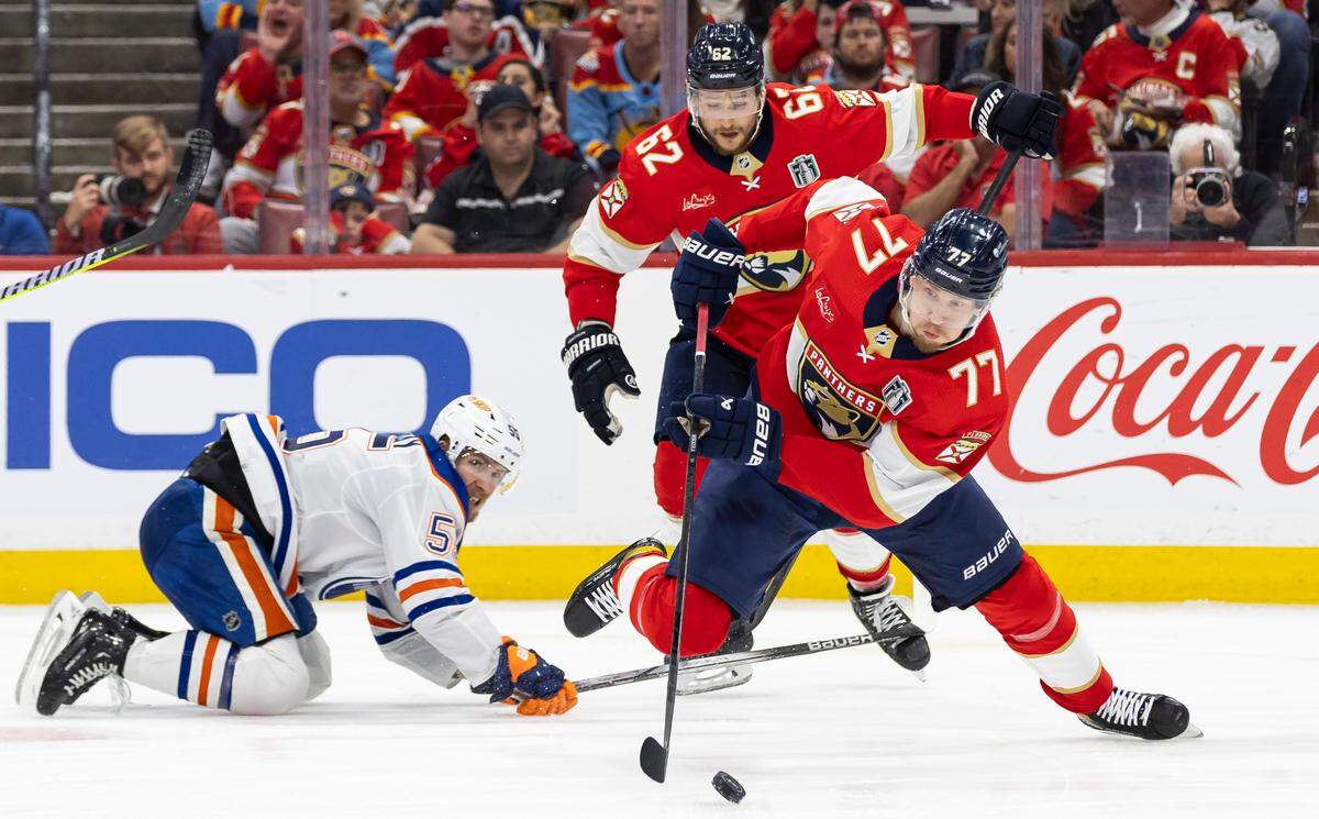 Florida Panthers defenseman Niko Mikkola (77) skates with the puck after recovering the puck from Edmonton Oilers left wing Dylan Holloway (55) in the second period of Game 5 of the NHL Stanley Cup Final at the Amerant Bank Arena on Tuesday, June 18, 2024, in Sunrise, Fla.