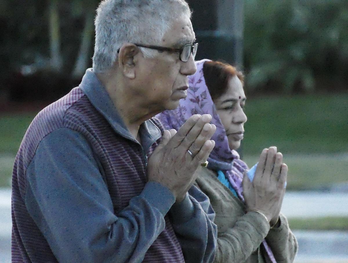 Kul and Kiran Bhushan Mody pray for the victims of the Marjory Stoneman Douglas shooting on the one-year anniversary outside of the school Thursday morning, Feb. 14, 2019. The couple, from India, is visiting family in Parkland.