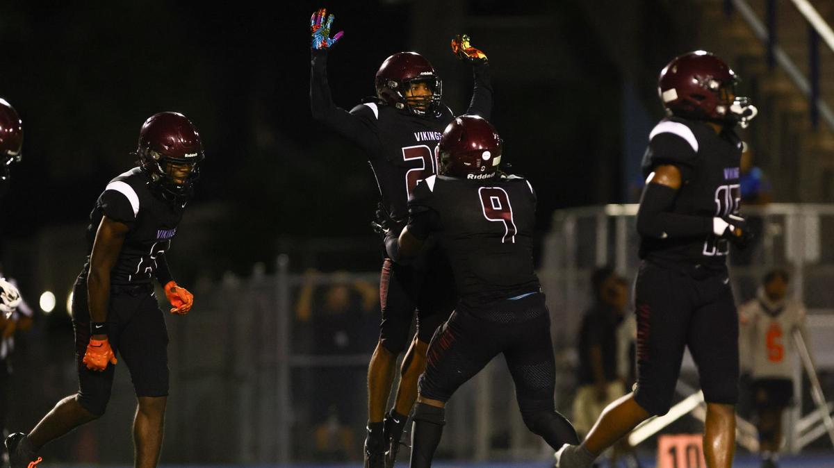 Norland Vikings cornerback Jerrard Smith (20) celebrates with defensive end Adrian Farrow (9) after intercepting the football against the Carol City Chiefs during the second quarter of a high school football game at Nathaniel Traz Powell Stadium in Westview, Florida, on Friday, August 30, 2024.