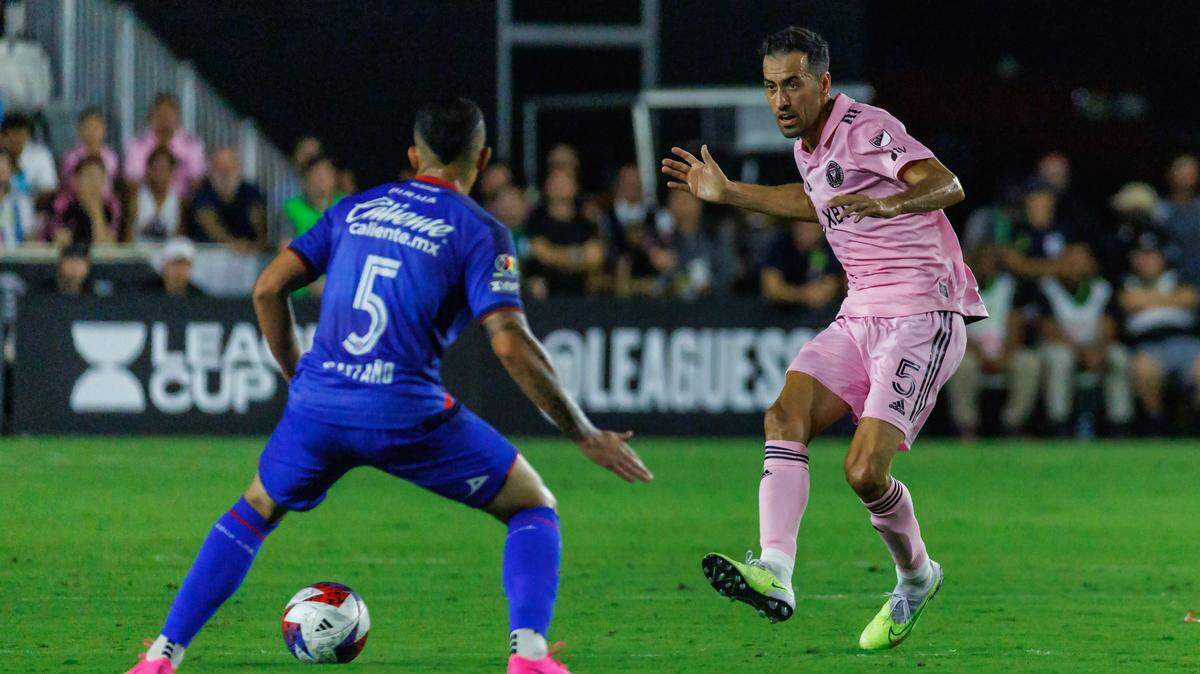El mediocampista del Inter Miami Sergio Busquets (der.) pasa el balón ante la defensa de Kevin Castaño, de Cruz Azul, en la segunda mitad del partido de la Leagues Cup, celebrado el 21 de julio de 2023 en el estadio DRV PNK, en Fort Lauderdale, Florida.