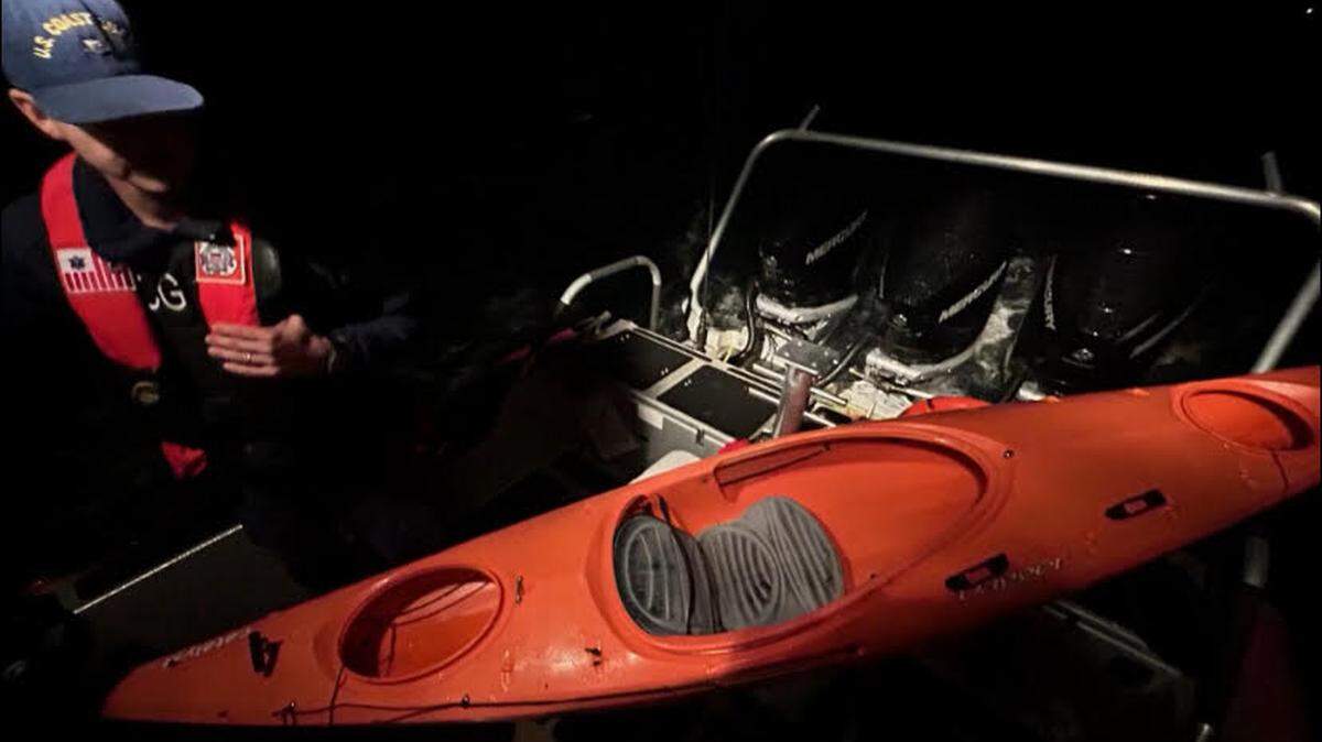 A U.S. Coast Guard crew member stands at the back of a patrol boat with a kayak on board Monday, Dec. 11, 2023. A man on the kayak needed rescuing after being caught in heavy weather off Key West, the agency said.