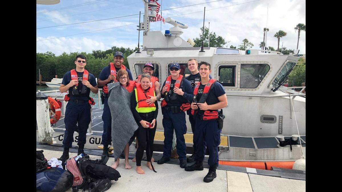 A Coast Guard Station Islamorada 45-foot Response Boat—Medium boatcrew take a moment for a group photo with three people they rescued in the vicinity of Windley Island, Florida after their boat began taking on water, Nov. 9, 2019.