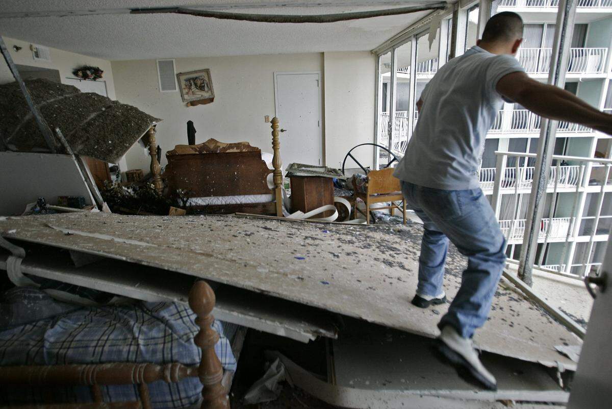 A resident climbs into his condo that was destroyed by Hurricane Wilma at Grand View Palace in North Bay Village.