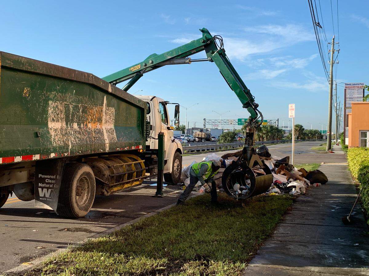 A crew cleans up the mess after firefighters dumped out a truck’s contents looking for a human.