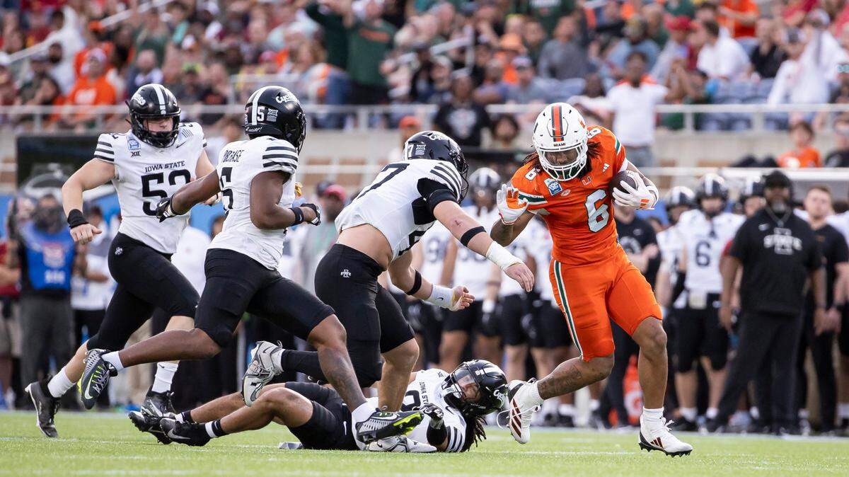 Miami Hurricanes running back Damien Martinez (6) tries to stiff-arm Iowa State Cyclones linebacker Kooper Ebel (47) in the first half of their Pop-Tarts Bowl football game at the Camping World Stadium on Saturday, Dec. 28, 2024, in Orlando, Fla.