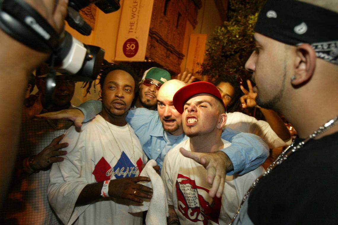 In 2004, rapper Vido, left, producer Jim Jonsin, center and Pitbull react to the tv cameras in the streets of Miami Beach.