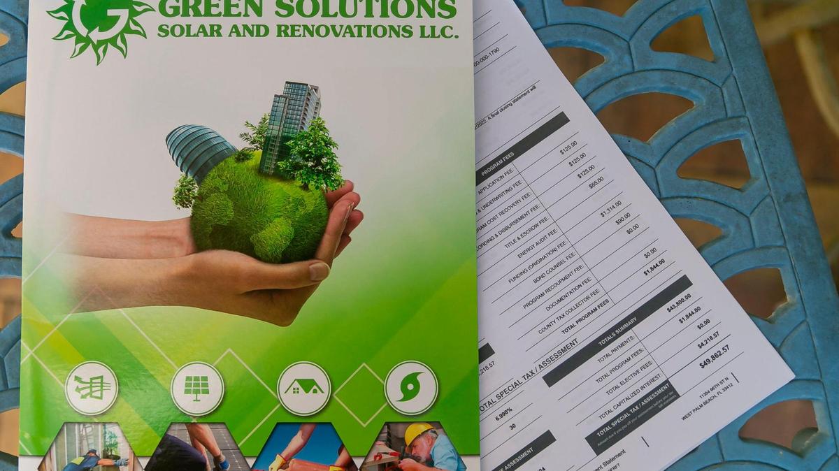Ray and Kelly Coulter display the paperwork from when they financed a new roof and impact windows on their West Palm Beach home through Green Solutions and Ygrene Energy Florida.