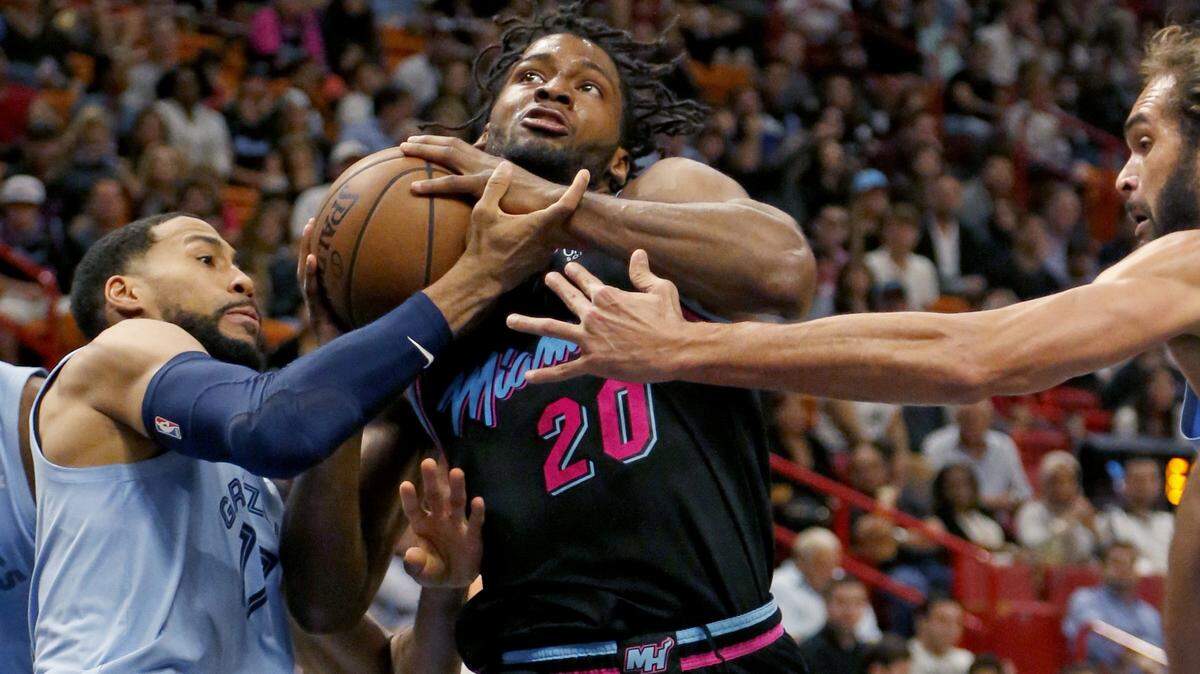 El armador del Heat Justise Winslow (20) penetra al aro entre dos jugadores de los Grizzlies el 12 de enero en el American Airlines Arena.