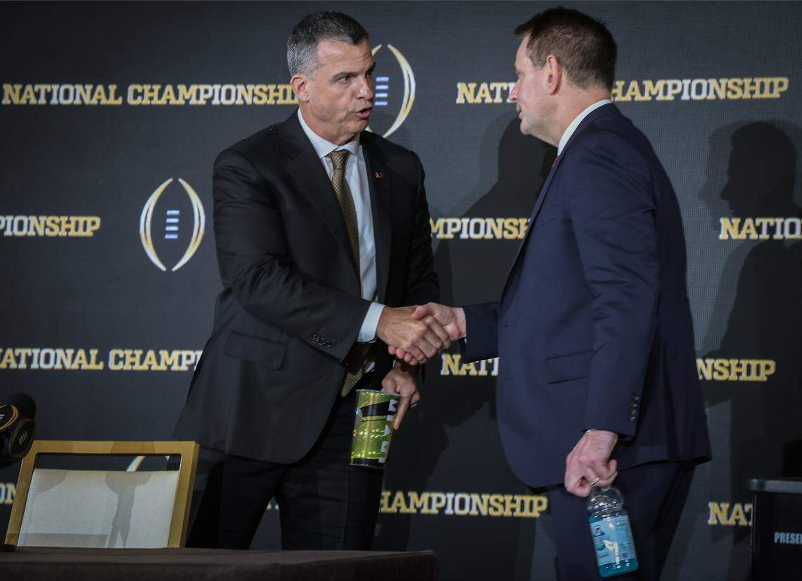 Miami head coach Mario Cristobal, left, and Indiana head coach Curt Cignetti, right, each of whom will lead their respective teams in the 2026 College Football National Championship, shake hands after their joint press conference prior to Monday night's National Championship game at Hard Rock Stadium, on Sunday, January 18, 2026, at the JW Marriott Marquis' Metropolitan Ballroom, in Miami, Florida.