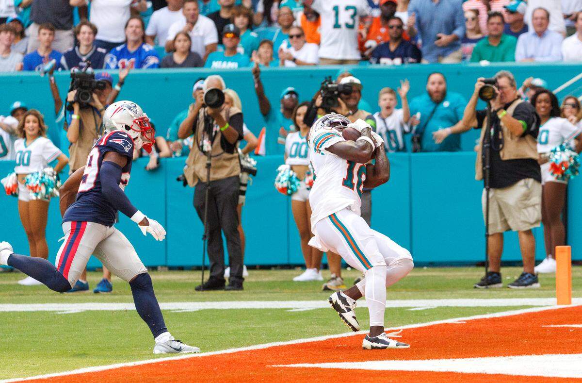 Miami Dolphins wide receiver Tyreek Hill (10) catches a pass for a touchdown New England Patriots cornerback J.C. Jackson (29) defends during first quarter of an NFL football game at Hard Rock Stadium on Sunday, Oct. 29, 2023 in Miami Gardens, Fl.