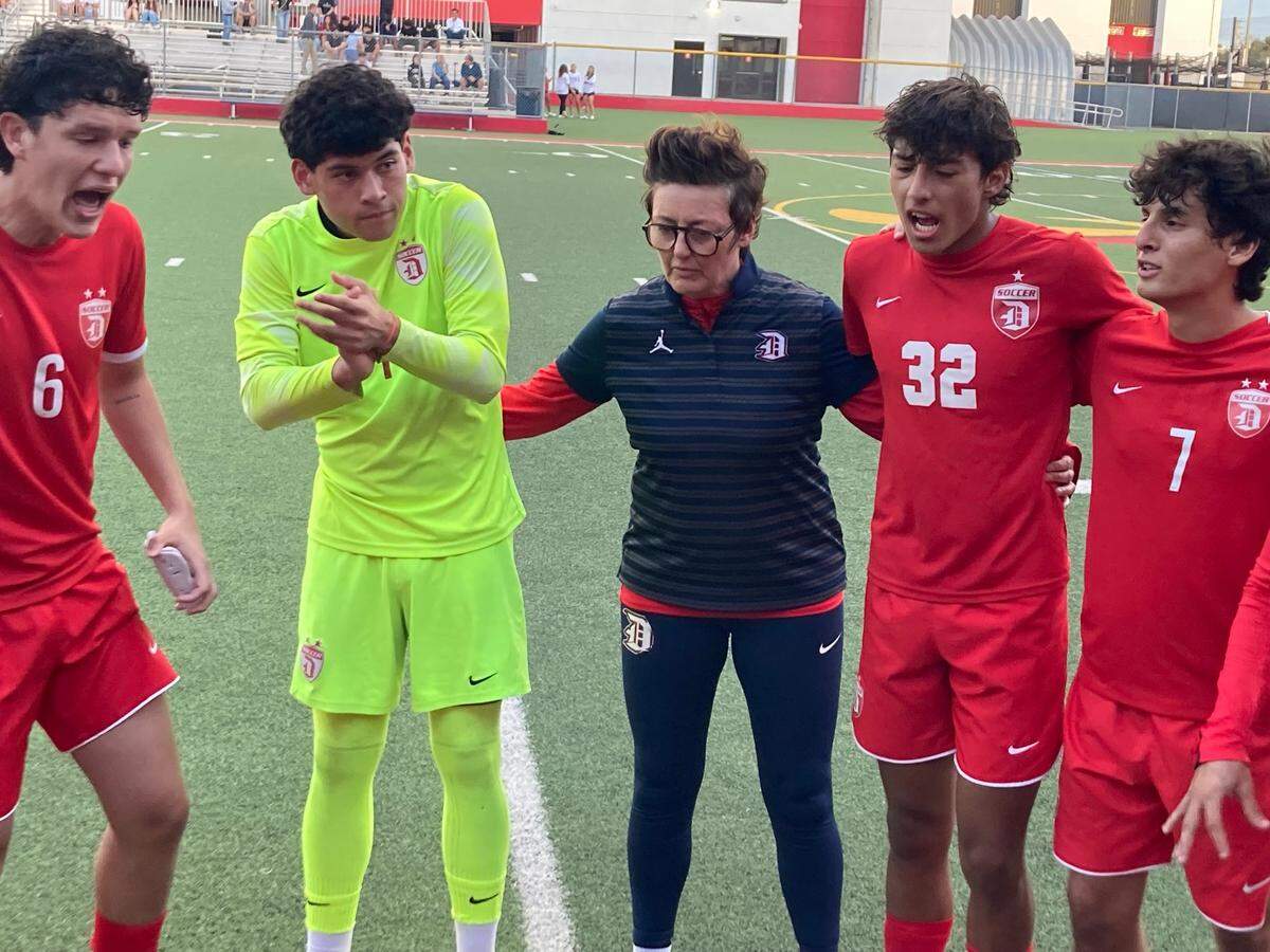 Doral Academy boys’ soccer coach Pamela McDonald (middle) gathers with four of her players before Wednesday night’s Region 4-7A championship match vs. Ferguson.