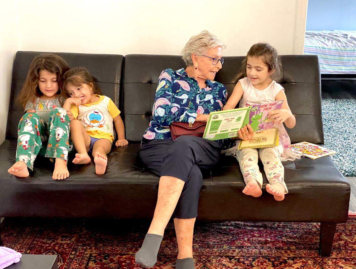 Refugee Assistance Alliance volunteer Marlene Broad reads with a refugee family.