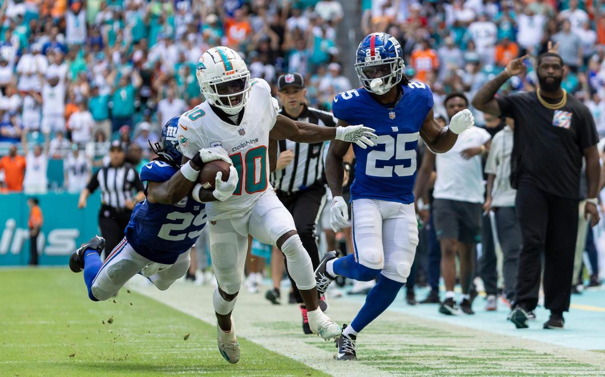 Miami Dolphins wide receiver Tyreek Hill (10) runs toward the goal line as New York Giants cornerback Deonte Banks (25) tries to stop him in the second quarter of an NFL game at Hard Rock Stadium on Sunday, Oct. 8, 2023, in Miami Gardens, Fla.